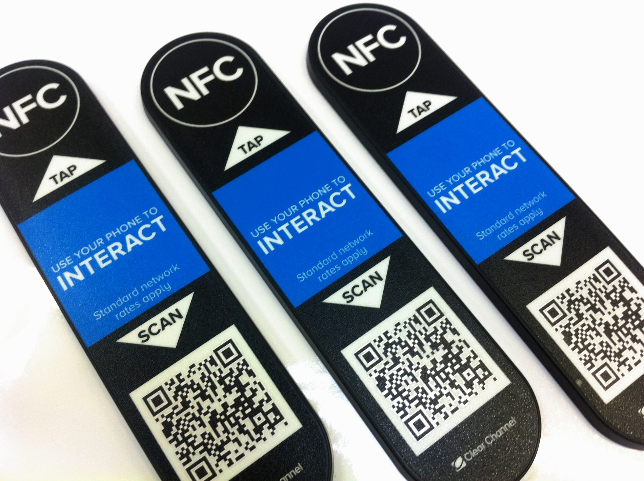 Three custom QR code labels on a white surface.