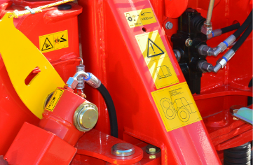 A close up of a custom red and yellow tractor with custom labels.