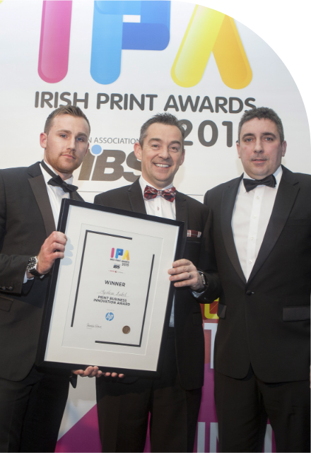 Three men posing with a high quality award at the Irish print awards.