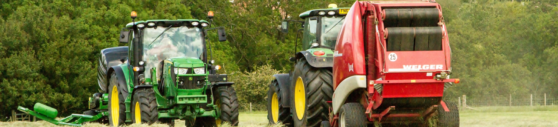 Two tractors adorned with decorative decals in a field next to each other.
