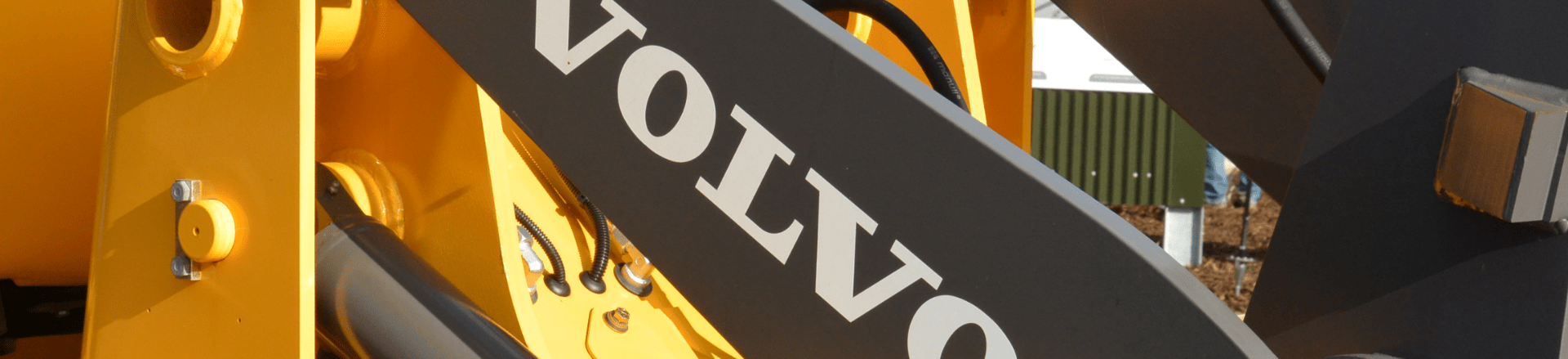 A close up of a yellow machine with custom labels featuring the word Volvo.
