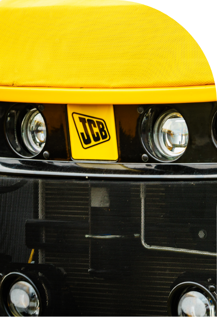A close up of the front end of a yellow truck with decals.