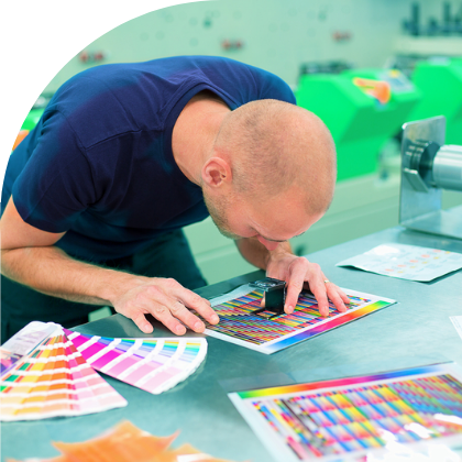 A man in a factory examining custom decals.