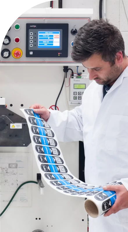 A man in a lab coat examining custom labels.