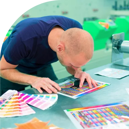A man in a factory examining custom decals.