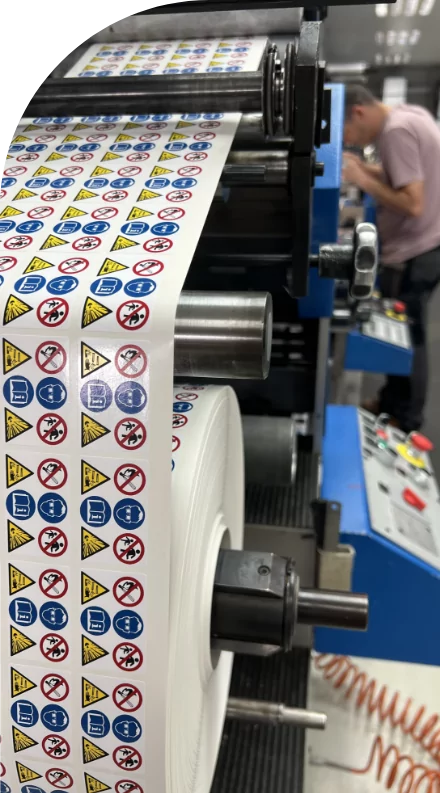 A machine is producing custom decals with medical labels on a sheet of paper.