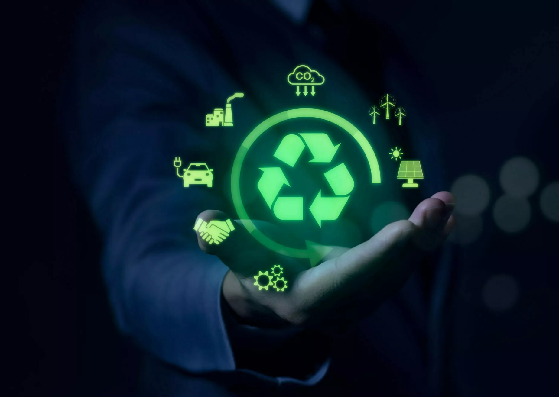 A businessman's hand holding a green recycle icon.
